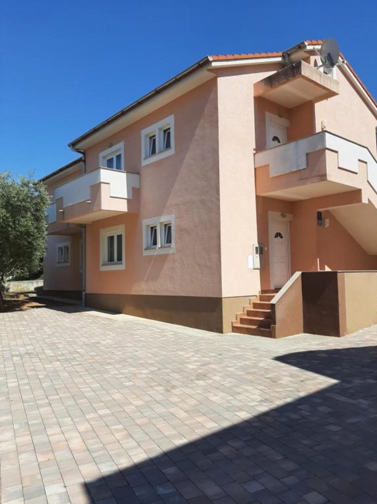 Dvorište i ulaz u apartmansku kuću u Novalji