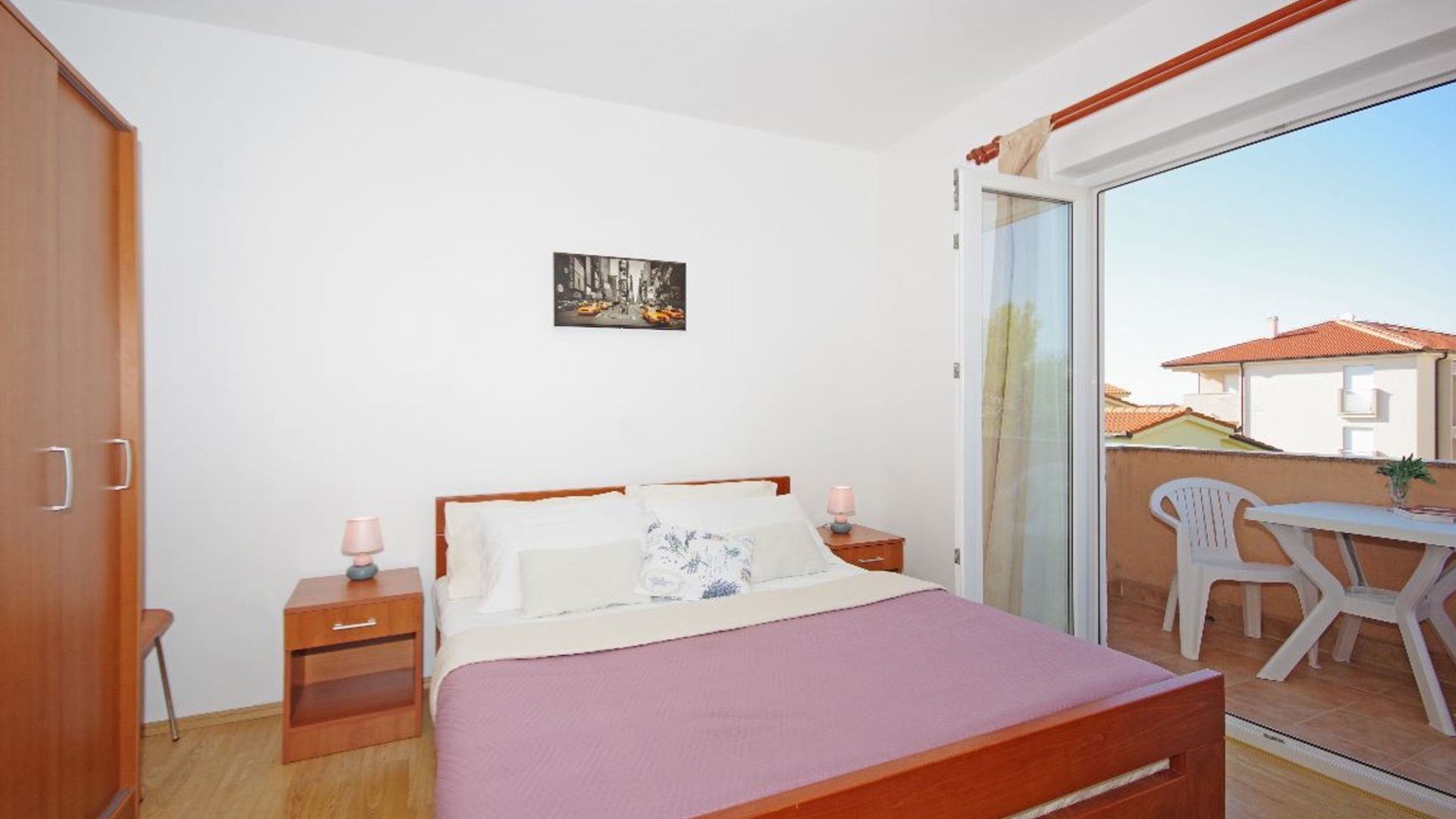 Spavaća soba apartmana u Novalji s bračnim krevetom i izlazom na balkon