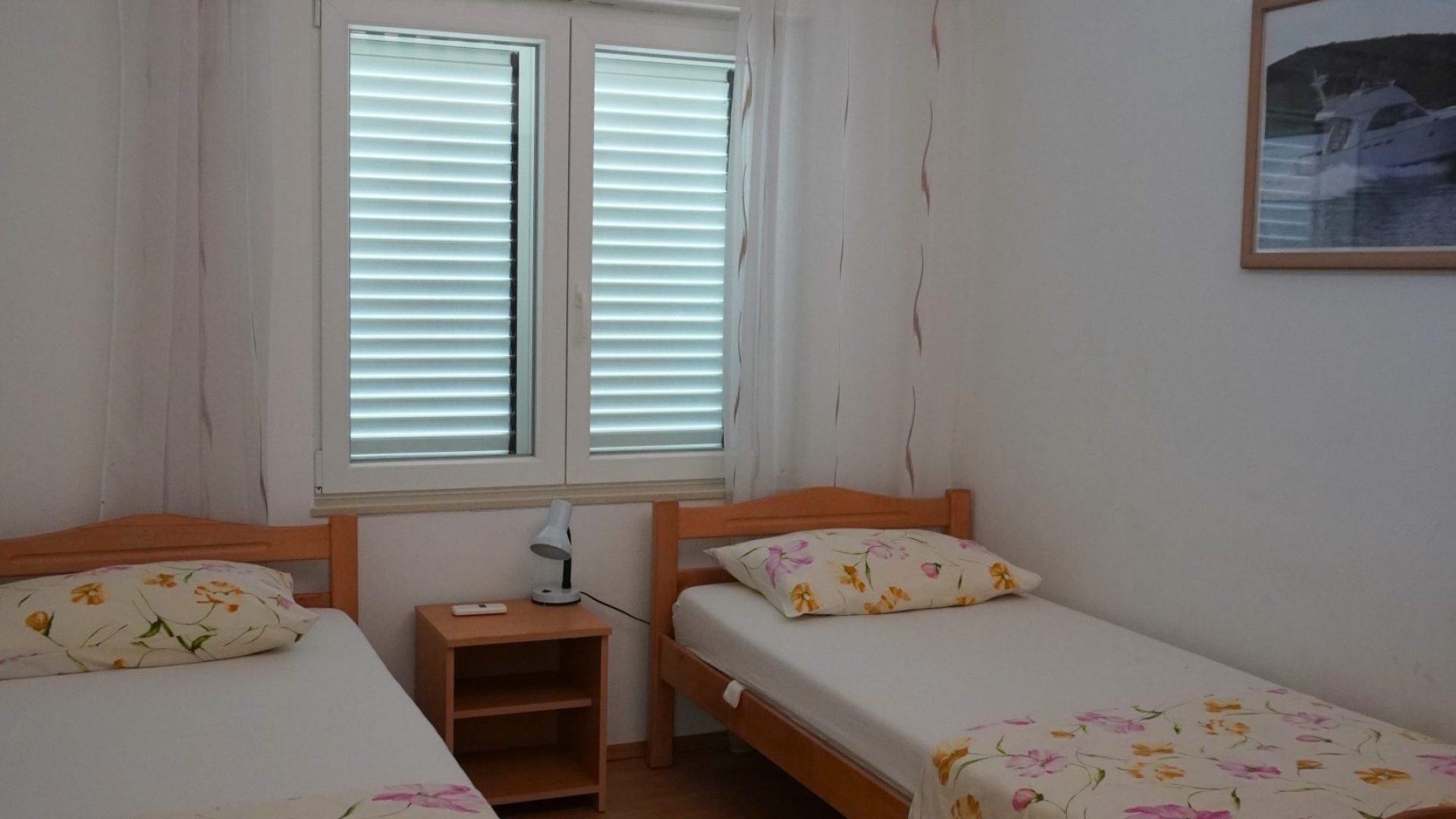 Spavaća soba s dva odvojena kreveta i noćnim ormarićem u apartmanu