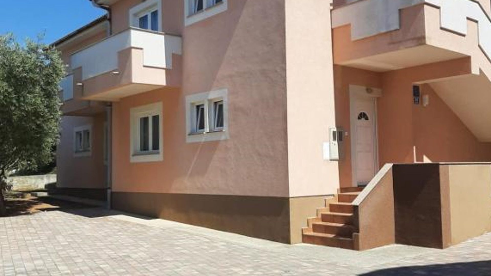 Dvorište i ulaz u apartmansku kuću u Novalji